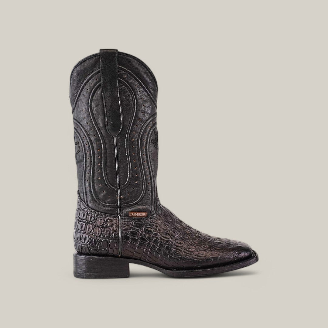 The Alligatoar Horn Back Print Black - Square Toe cowboy boot has a textured crocodile pattern and black shaft with decorative stitching. Expert leather craftsmanship is evident in the low heel, subtle brand tag near the ankle, and unique square toe design.