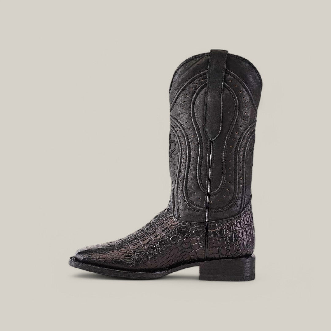 The Alligatoar Horn Back Print Black - Square Toe cowboy boot features an embossed crocodile pattern and intricate shaft stitching, highlighting exceptional leather craftsmanship. Its square toe design stands out elegantly against a light beige background in the side view.