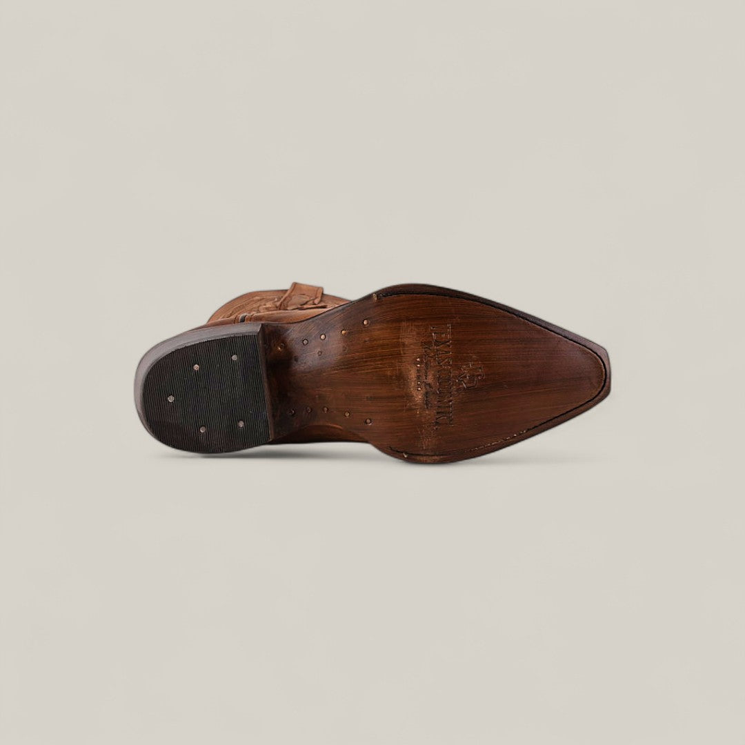 The image displays the bottom view of Fresno - Tabaco - Snip Toe, a leather dress shoe with a pointed toe, visible stitching showcasing quality craftsmanship, metal nails on the heel and sole, and branding near the arch on its brown sole.