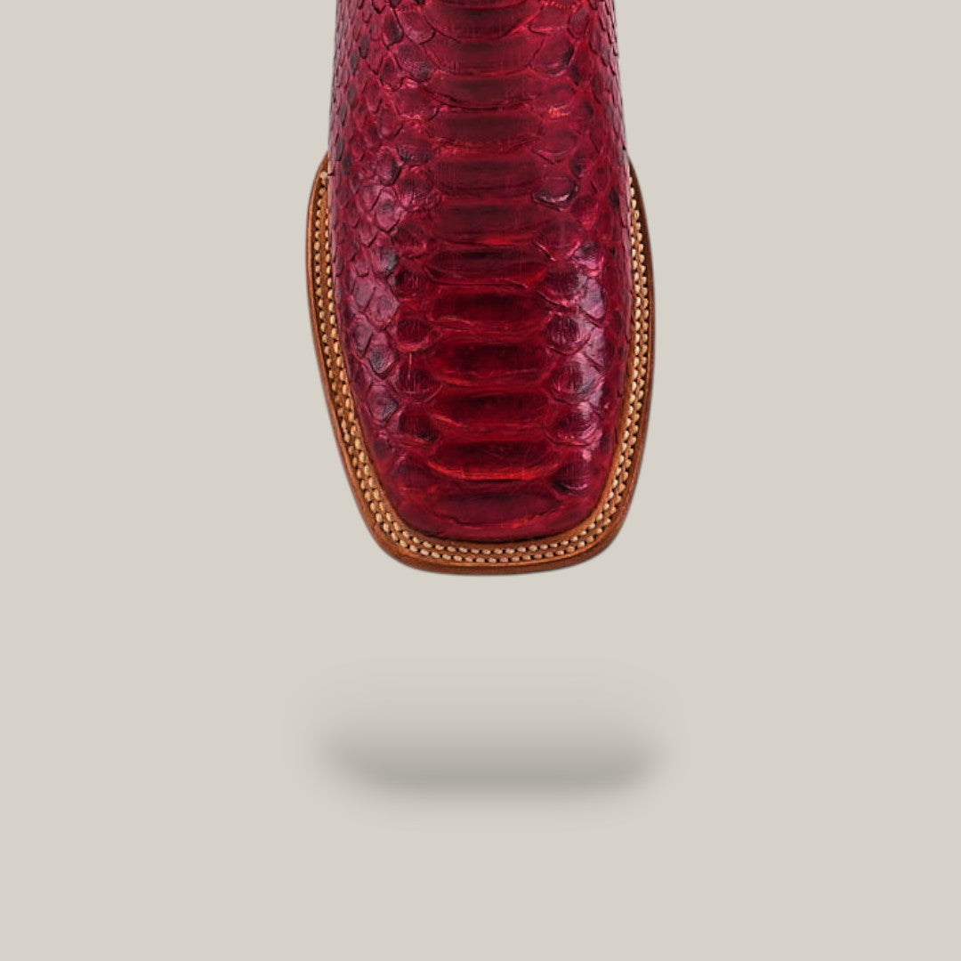 Close-up of the Exotic Python - Ruby / Blue - Square Toe boot, highlighting detailed stitching, from the Platinum Collection, displayed against a plain beige background with a subtle shadow underneath.