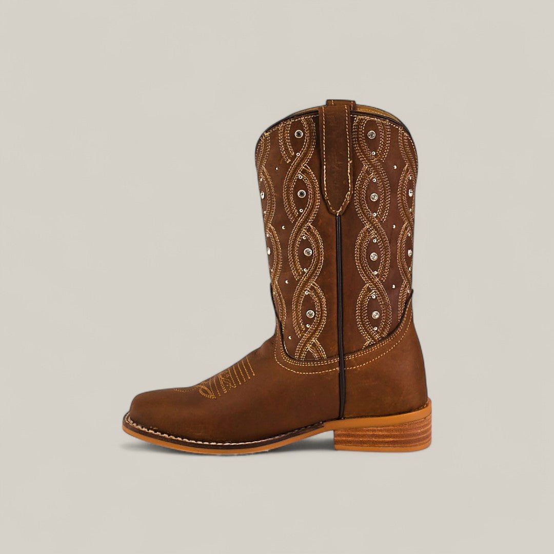 The Premiere Texas Copper - Square Toe Kids Boots feature brown leather, decorative white stitching, small silver studs on the shaft, a classic square toe, and a wooden heel, displayed on a plain light background.
