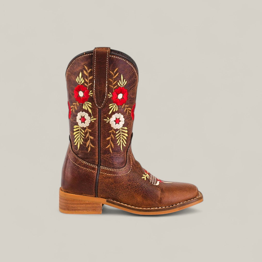 The Karo Brown - Square Toe - Kids Boots offer classic style with a low heel and red, white, and yellow floral embroidery on the shaft. Displayed from the side against a light gray background.