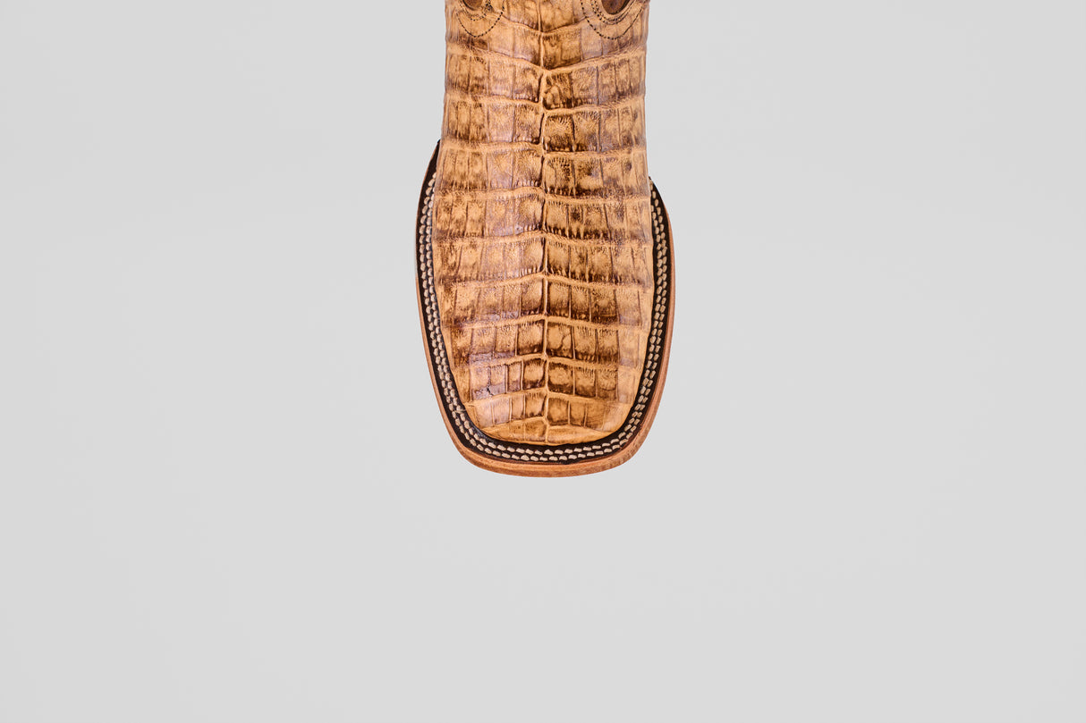 Close-up of the Exotic Caiman Belly - Antique - Square Toe boot’s toe, showcasing textured caiman leather with a crocodile pattern and detailed edge stitching, set against a light gray background.