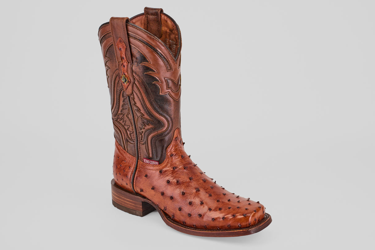 A single Exotic Ostrich - Brandy - Rodeo Toe boot, crafted from genuine ostrich leather with decorative stitching and textured bumps, pointed toe, low heel, and pull straps, shown on a plain light gray background.