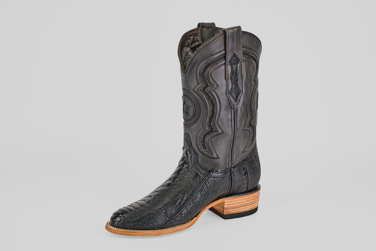 The Austin Leg - Black - Roper Toe is a single black western boot with decorative shaft stitching, a textured leather foot, and a light brown wooden heel and sole, set against a plain white background.