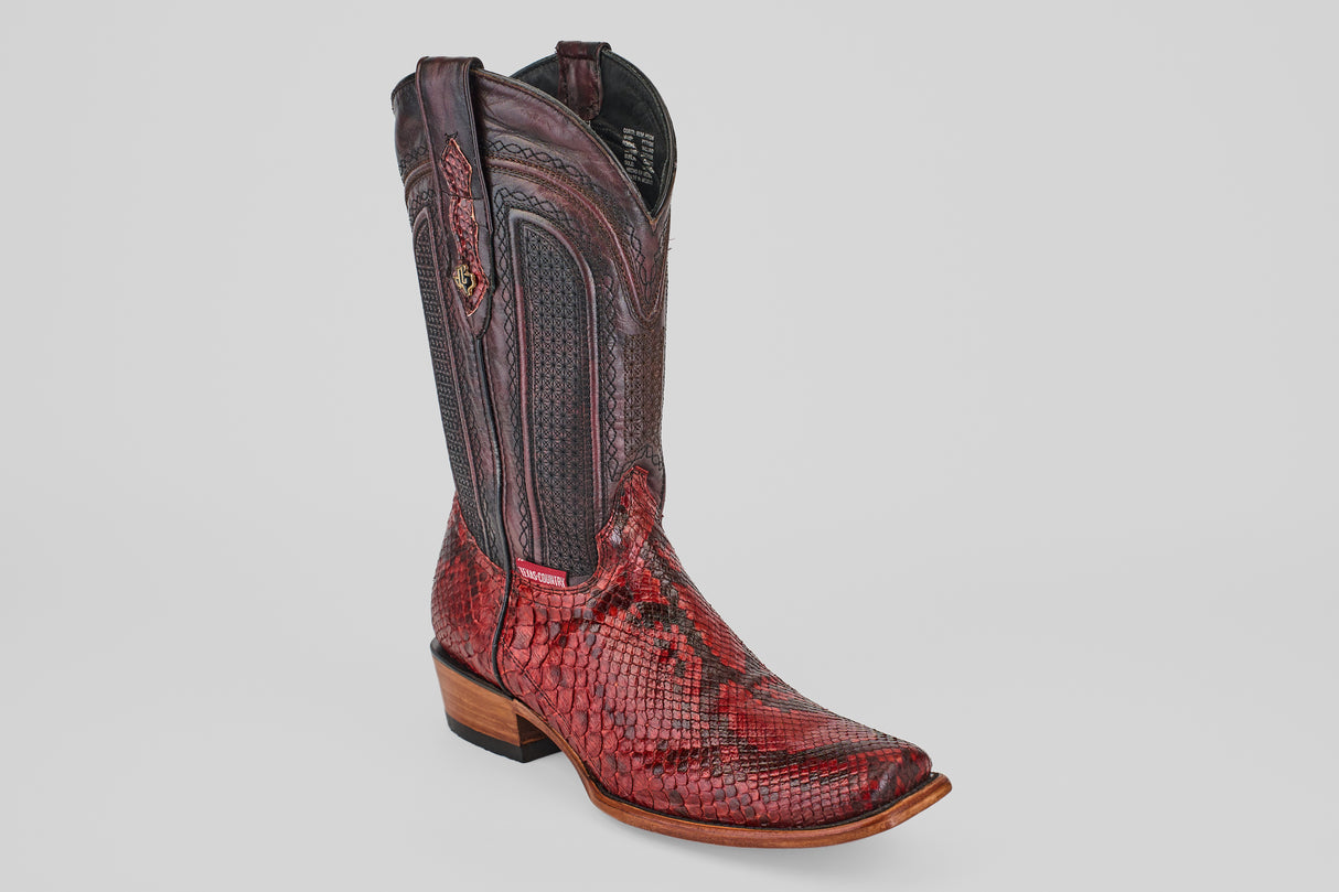 The Tanner – Ruby – Narrow Square Toe is a single western boot made of red and brown python leather with a narrow square toe, decorative stitching, and a wooden heel, displayed against a plain white background.