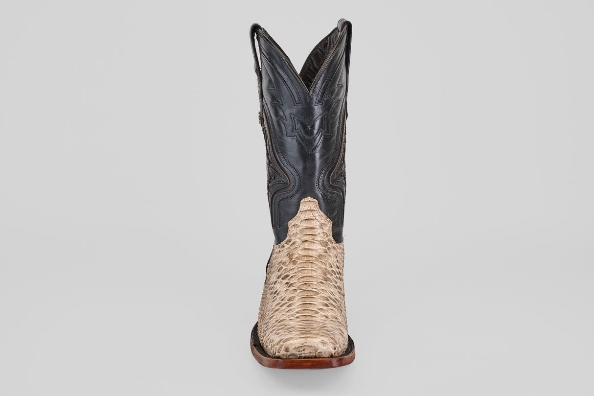 The Tanner - Natural - Rodeo Toe boot features a light tan Python Natural lower and a dark, decorative upper shaft, shown from the front on a plain gray background for an authentic Rodeo look.