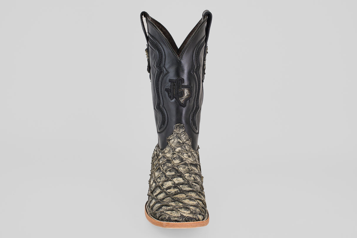 The Conor - Rustic Bone - Square Toe men's cowboy boot features a black leather upper and textured, scaly tan fish leather lower section, shown from the front on a plain light gray background.