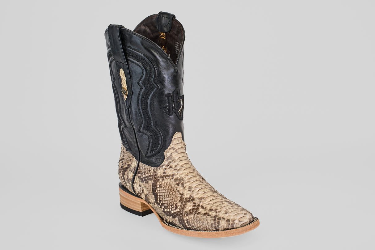 The Tanner - Matte Natural - Square Toe is a cowboy boot with a black upper and tan matte natural python leather lower, decorative stitching, a light wooden heel, and square toe—shown on a plain light gray background.