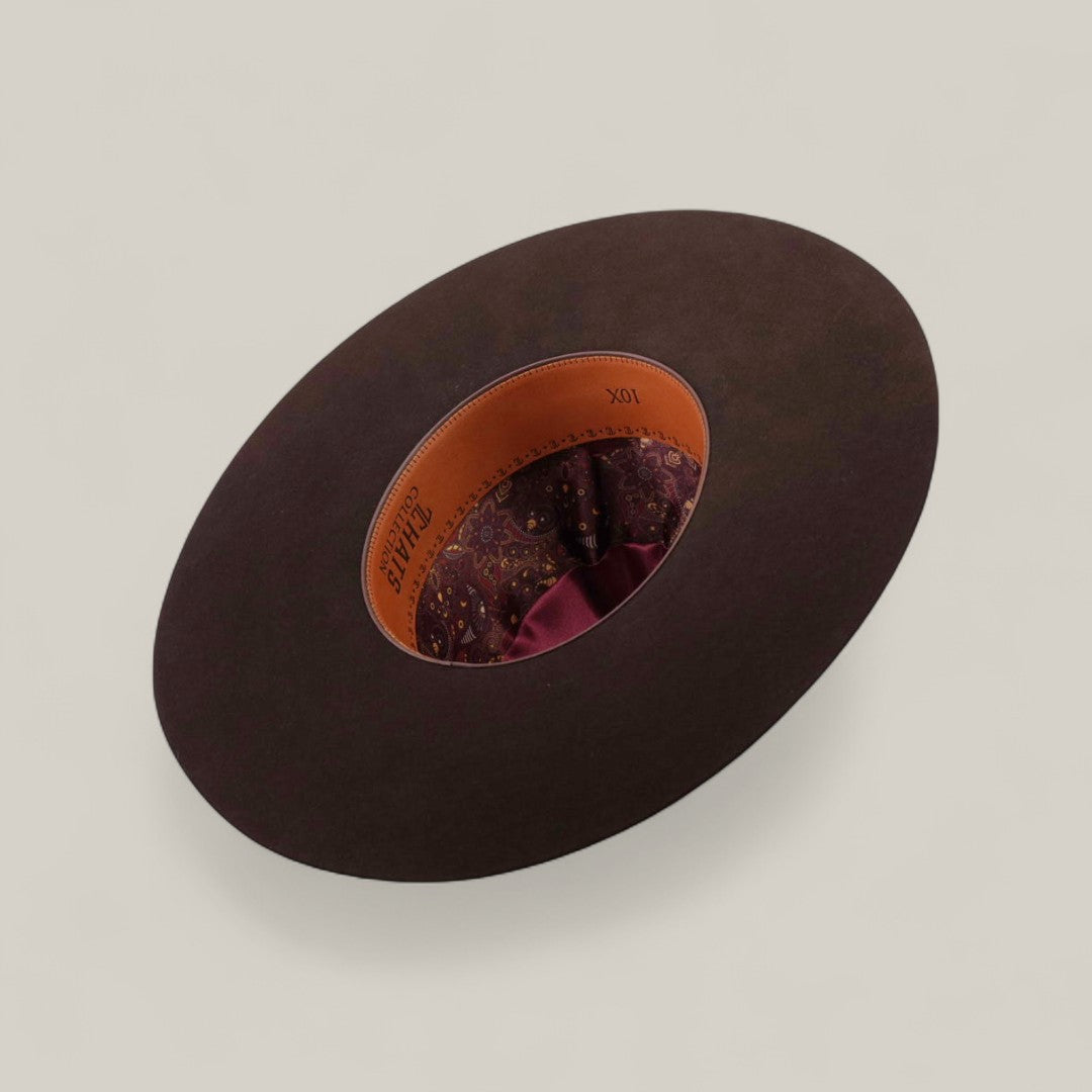 The 10X - Chocolate - TC Hats is a wide-brimmed brown Open Crown Texana hat shown from above, with a tan leather interior band, paisley-patterned fabric lining, and a burgundy ribbon on a plain light background.