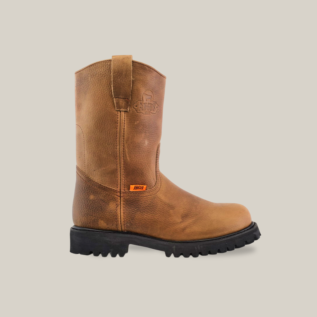 The Tan Roper - Tractor Sole - Soft Toe is a durable work boot made from premium cowhide leather. It includes a pull tab, visible stitching, and a small orange tag with text on the upper side, all set against a plain white background.