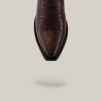 The Miranda Clayton Brownie Leather Sole boot features a brown leather snip toe and decorative stitching, shown from above on a beige background with a soft shadow. Its classic mid-shaft style and quality craftsmanship stand out.