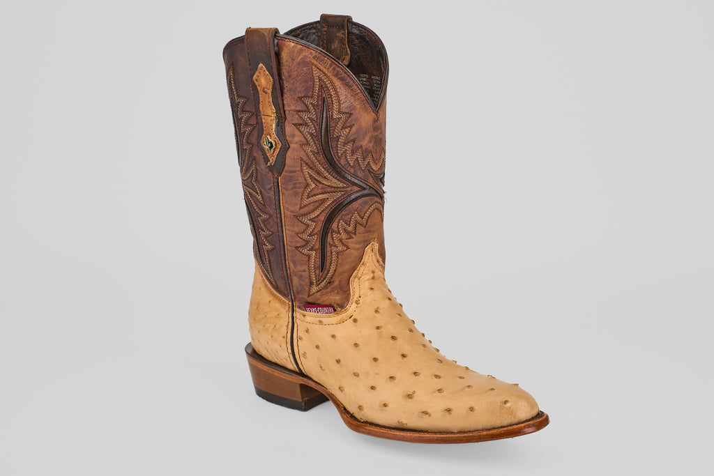 The Exotic Full Quilt Ostrich - Orix - Round Toe cowboy boot features a tall, brown stitched leather upper and a light tan, textured full quill ostrich leather foot, showcased against a plain white background.