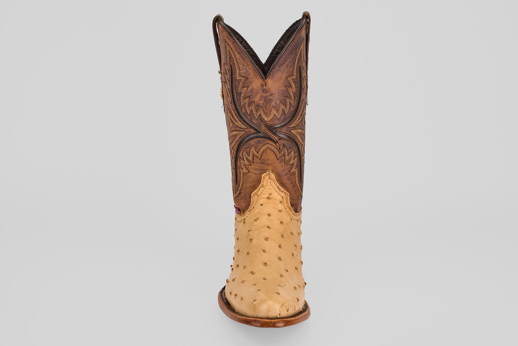 The Exotic Full Quilt Ostrich - Orix - Round Toe boot stands upright, featuring a tan quilted ostrich lower and a dark brown, ornately stitched upper, handcrafted in classic Western style on a plain light gray background.