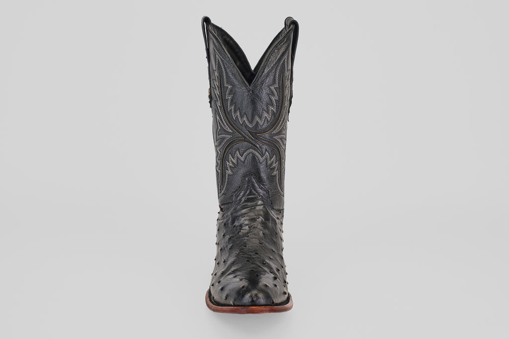 The Exotic Full Quilt Ostrich - Black - Round Toe boot features decorative stitching and classic Western style, displayed front-facing against a plain light gray background.