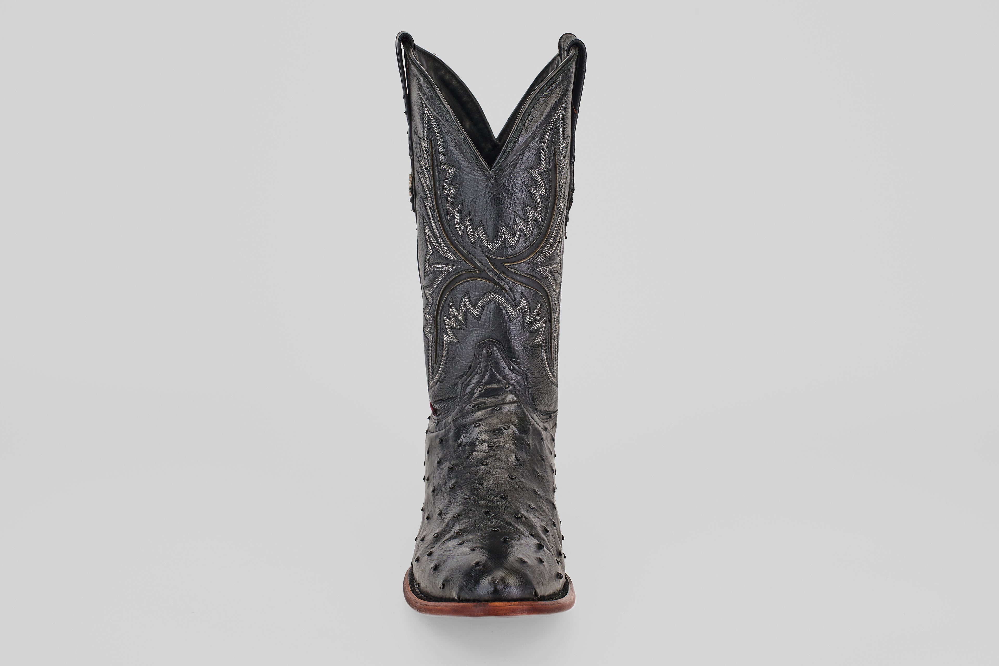 The Exotic Full Quilt Ostrich - Black - Round Toe boot features decorative stitching and classic Western style, displayed front-facing against a plain light gray background.