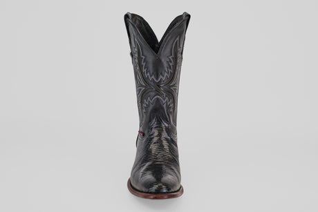 The Blaze – Black – Round Toe boot stands upright against a light gray background, showcasing its decorative stitching, round toe, and gently worn leather texture for a timeless cowboy style.