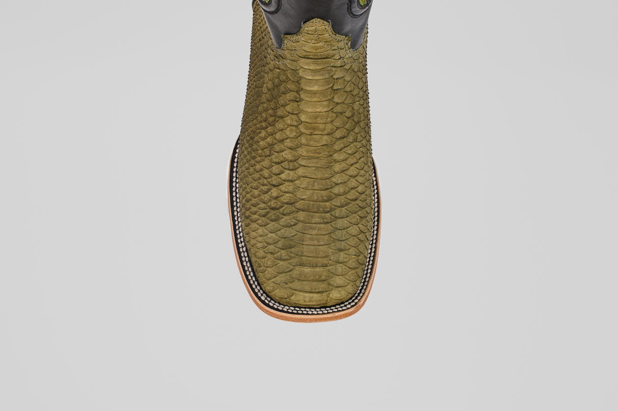A top view of the Tanner - Green Jungle - Square Toe boot shows its olive green python leather, square toe, decorative stitching around the sole, and light brown outsole, embodying classic western style against a plain light background.